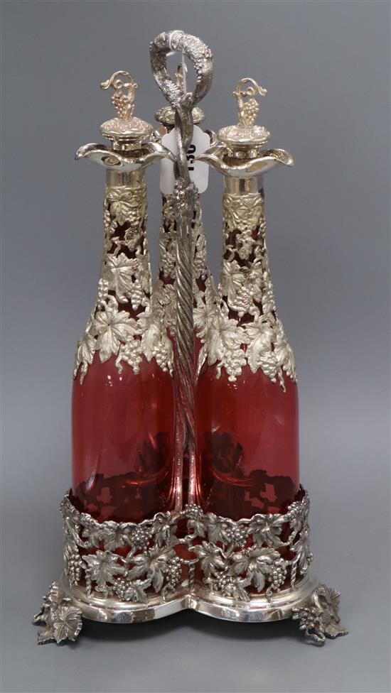 A decanter stand with three cranberry glass decanters and stoppers height 45cm